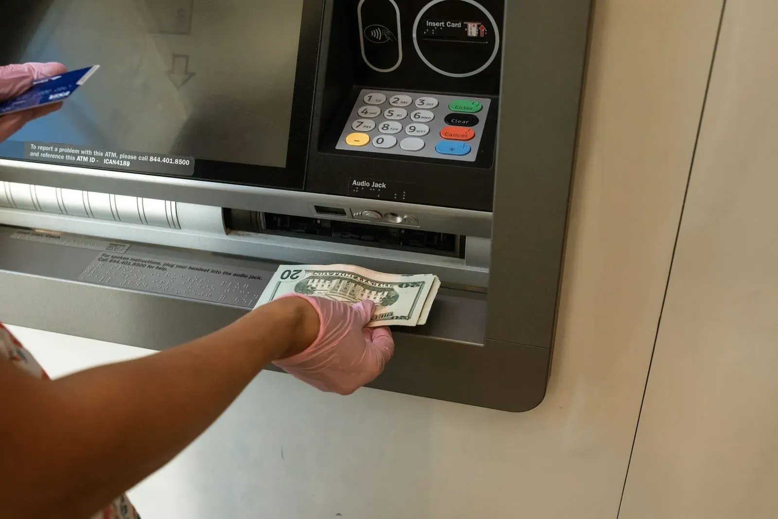 Person withdrawing Thai baht cash from an ATM machine on Koh Samui