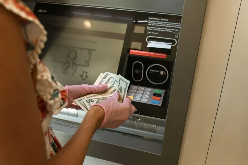 Tourist counting Thai baht notes withdrawn from a Koh Samui cash machine