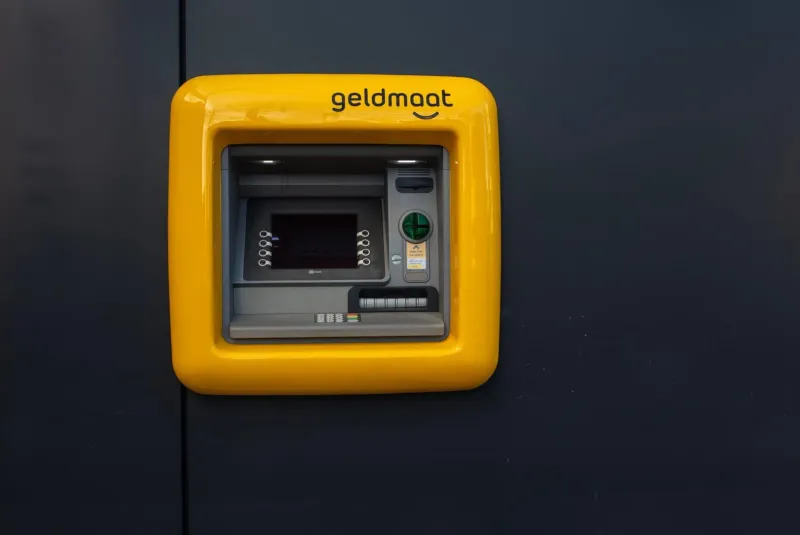 Bancomat giallo acceso montato su un muro per prelevare contanti in Thailandia