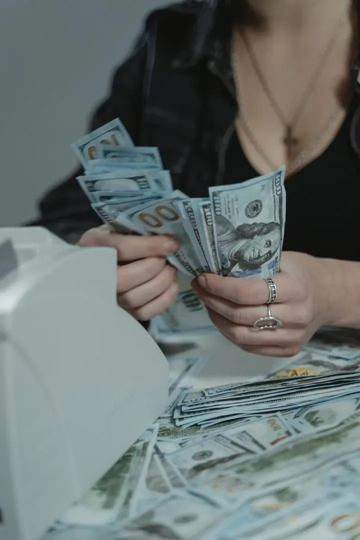 Hands counting Thai baht cash notes for a restaurant or tour tip on Koh Samui