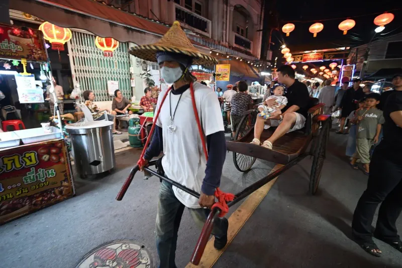 Rickshaw and food vendors under red lanterns at a Koh Samui-style night market
