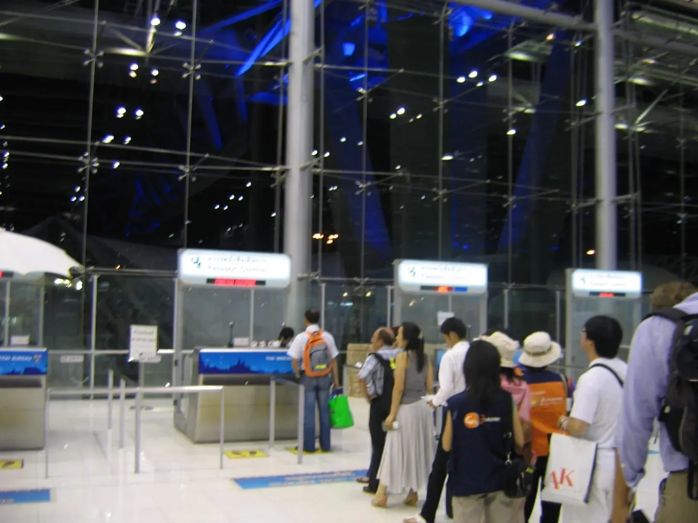 Passengers at a passport and immigration control counter at a Thailand international airport