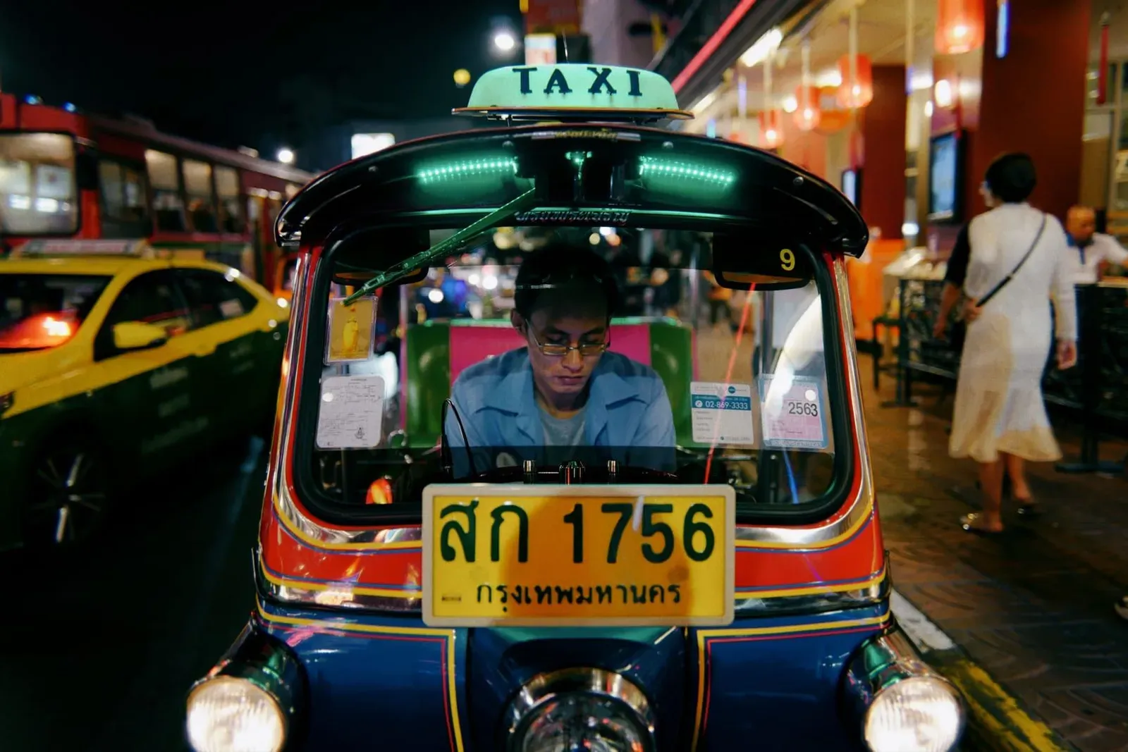 Thai taxi driver navigating a busy street where fares are rarely metered