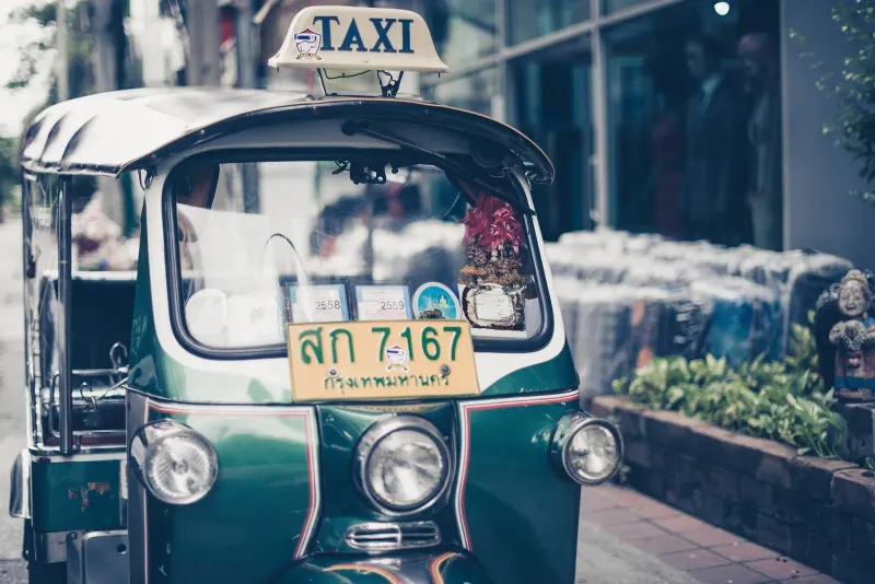 Green and yellow Bangkok taxi representing Thailand's flat-fare taxi culture