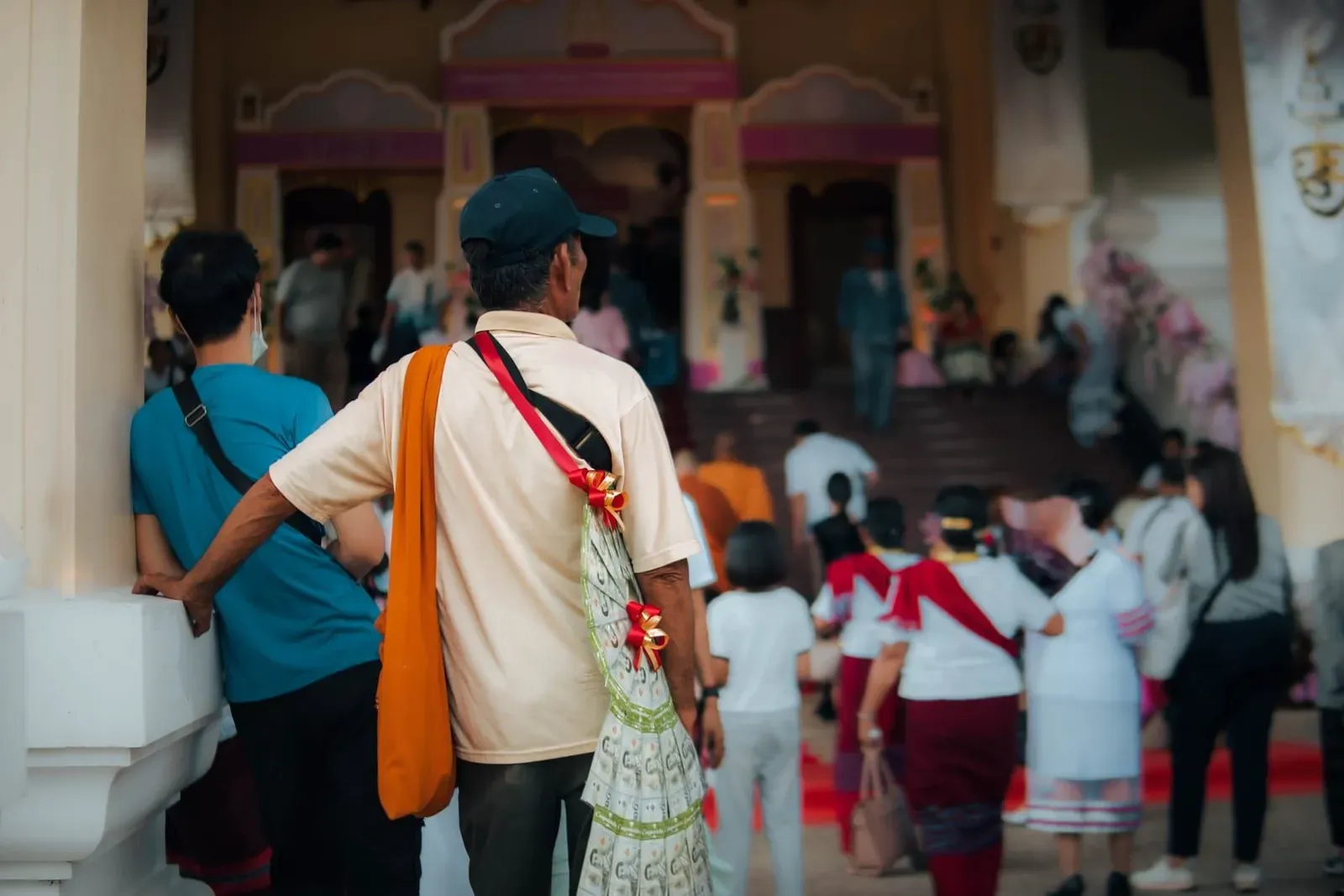 Group of visitors gathered respectfully at a Thai temple entrance before removing shoes
