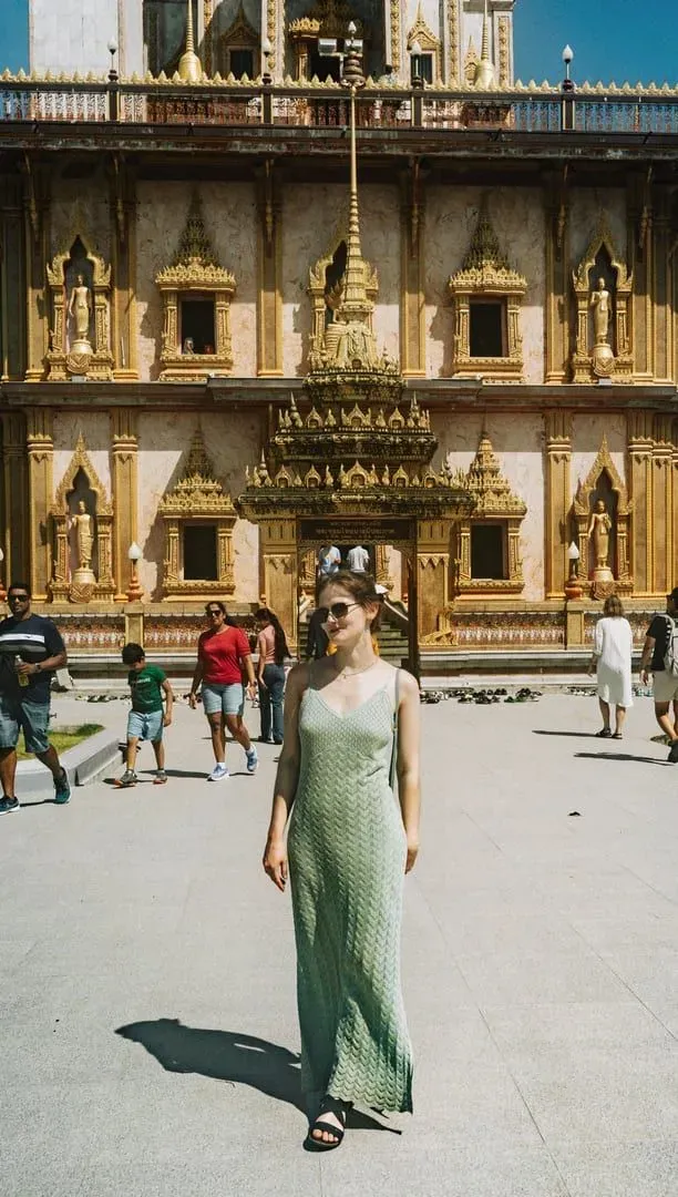 Tourist wearing knee-length dress in front of a Thai Buddhist temple