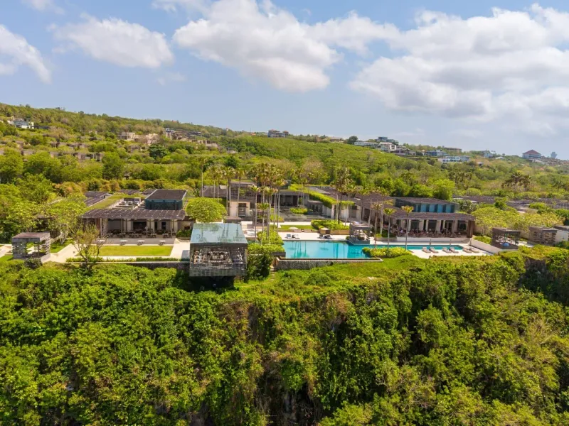 Aerial view of a cliffside pool villa overlooking the sea, similar to Taling Ngam's resort layout