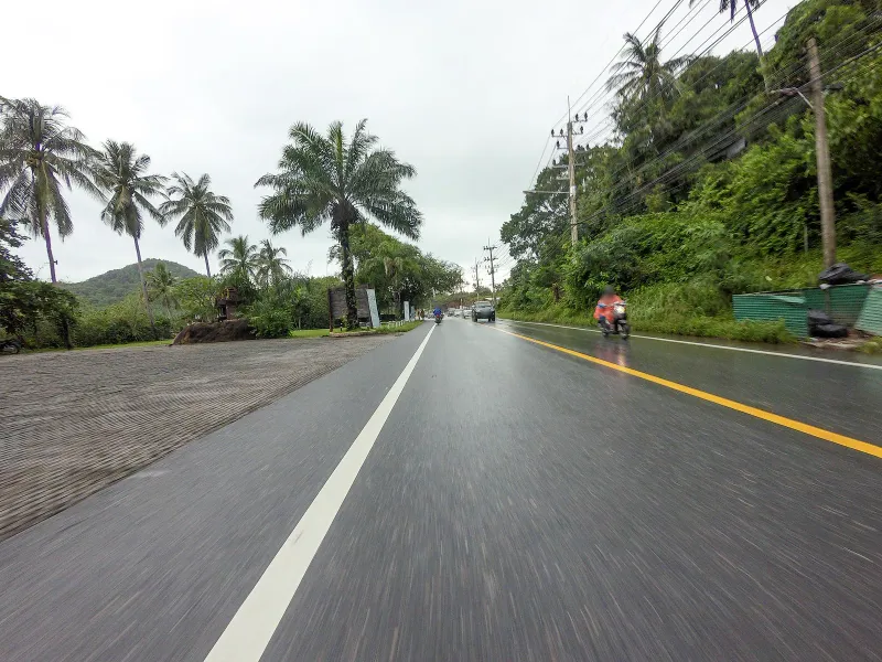 Palm-lined coast road with hillside views close to The Cliff restaurant, Koh Samui