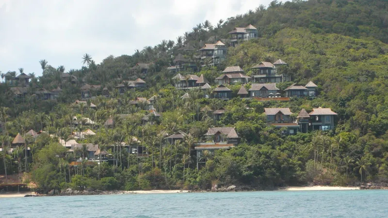 Resort villas on a forested hillside above Laem Yai Bay, seen from the water