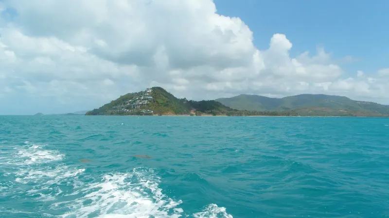 The terraced hillside headland and surrounding hills on Koh Samui's southwest coast, seen from a boat