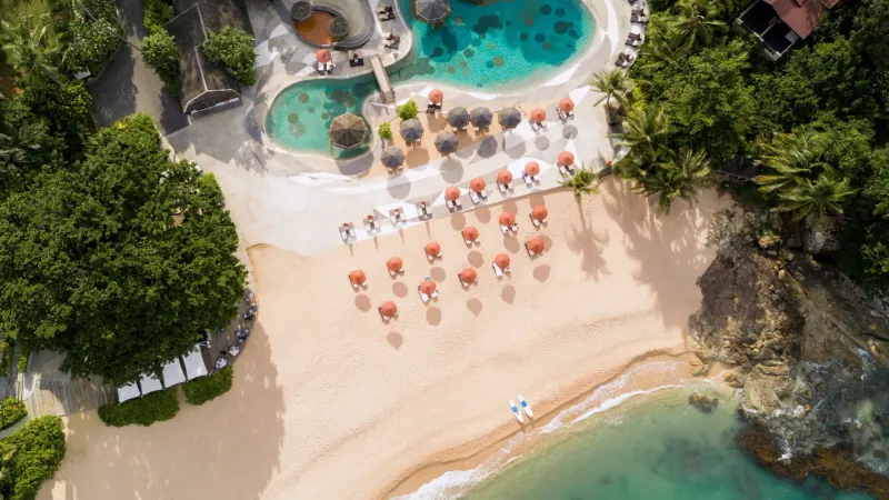 Luftaufnahme von Strandschirmen und Pools entlang des Sands von Tong Sai Bay
