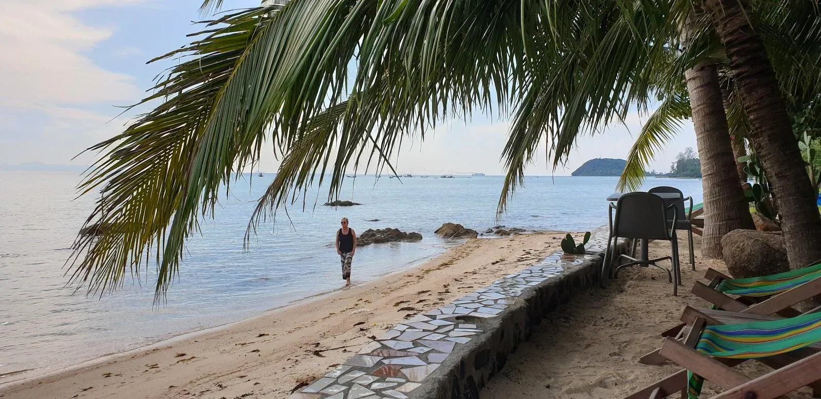 Palmenbeschatteter Strandwinkel mit ein paar Liegen, keine Menschenmassen