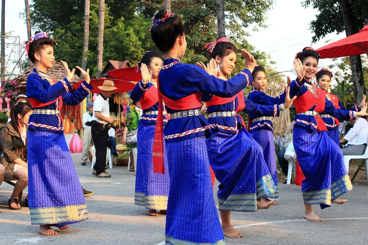 Dancers in blue Thai costumes performing outdoors