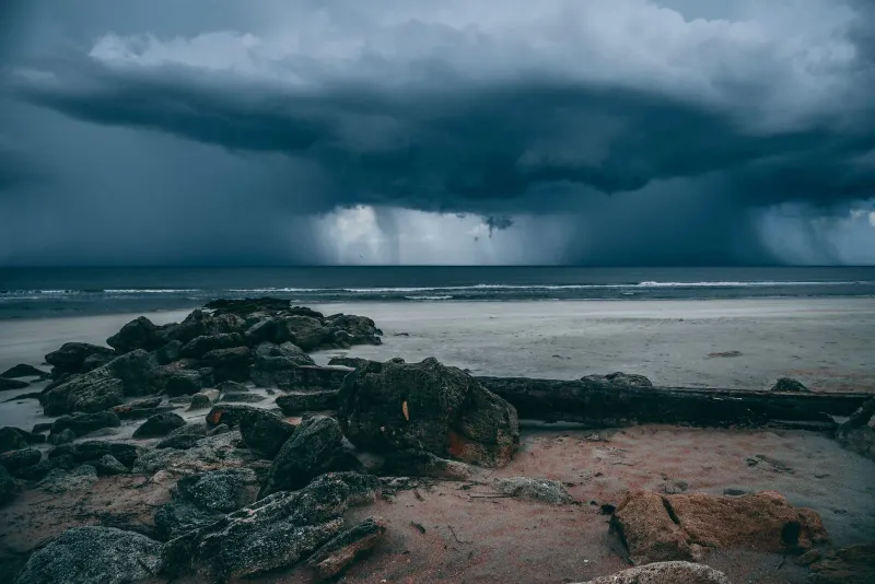 Moody storm clouds over a rocky Koh Samui coastline during a rainy season squall