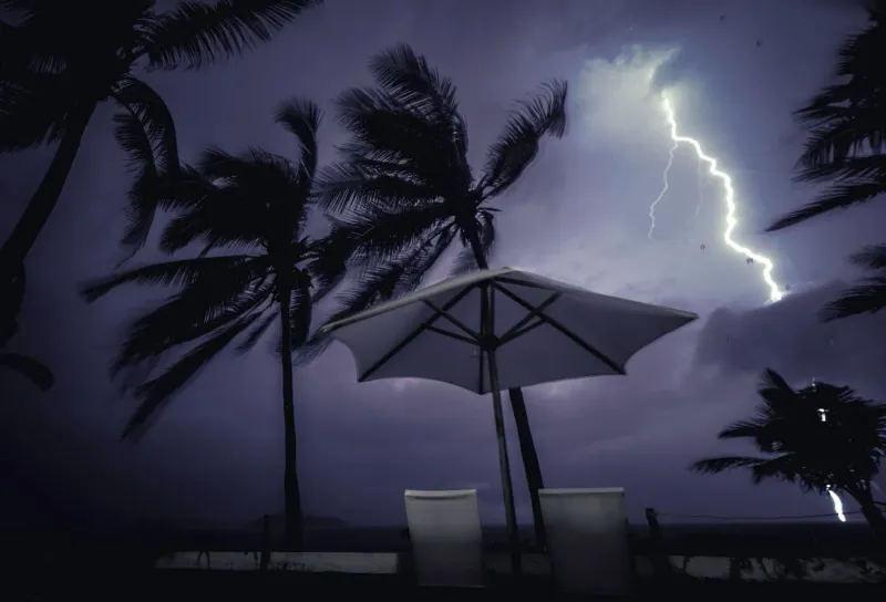 Lightning striking over palm trees during a Koh Samui monsoon storm at night