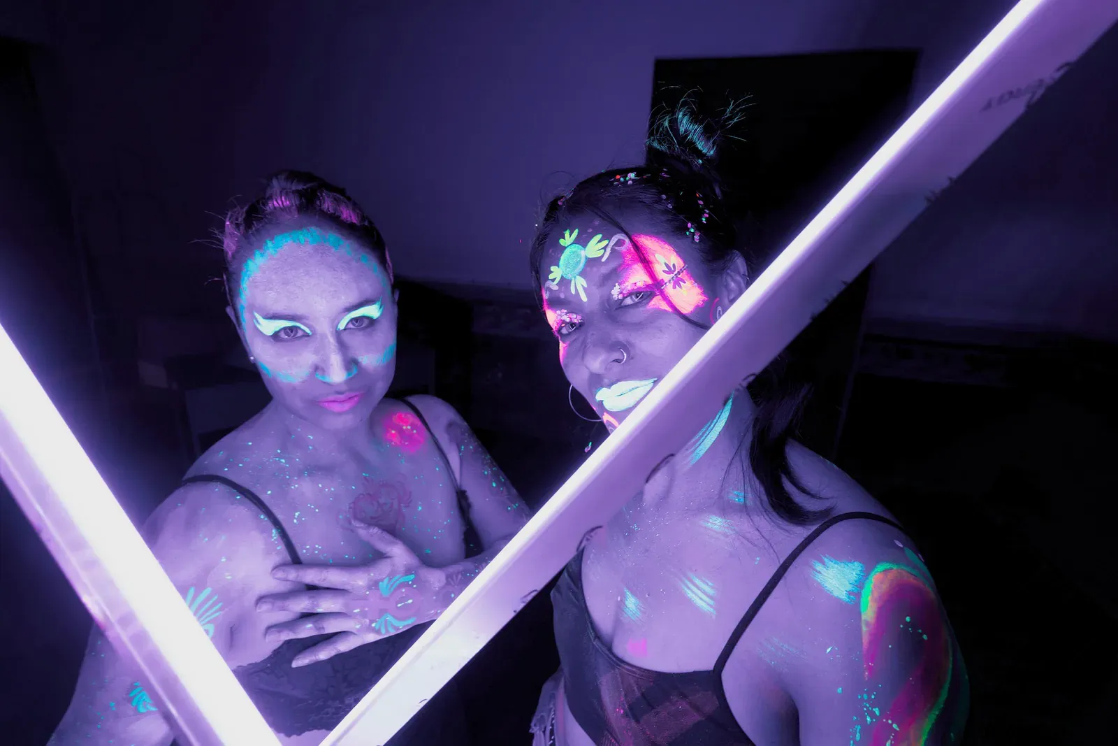 Two women with glowing UV face paint