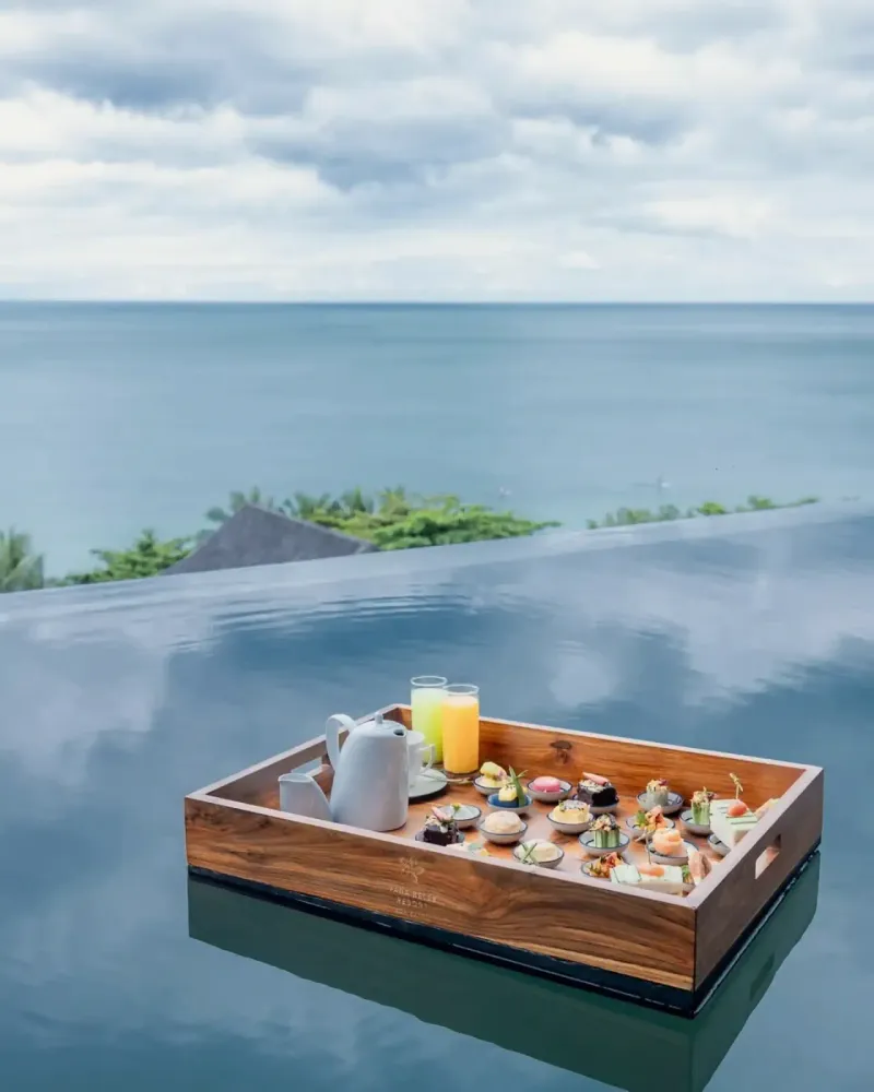 Plateau de petit-déjeuner flottant dans une piscine privée de Vana Belle, avec la mer au fond