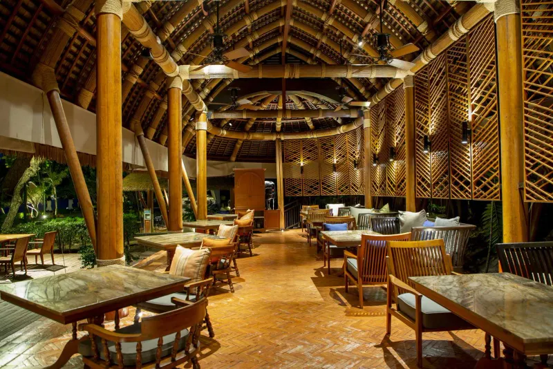 Pavillon de restaurant ouvert en bois, sous un haut toit de chaume, à Vana Belle Koh Samui