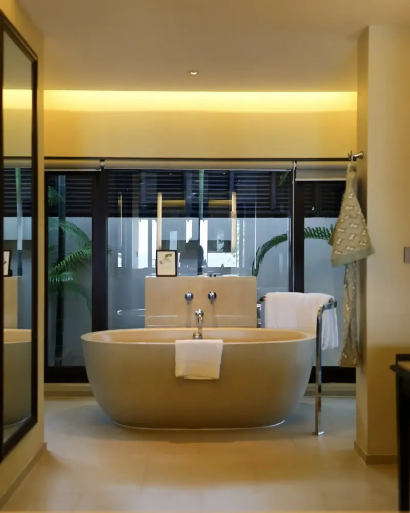 Salle de bains d'une suite de Vana Belle, avec baignoire îlot et éclairage chaleureux