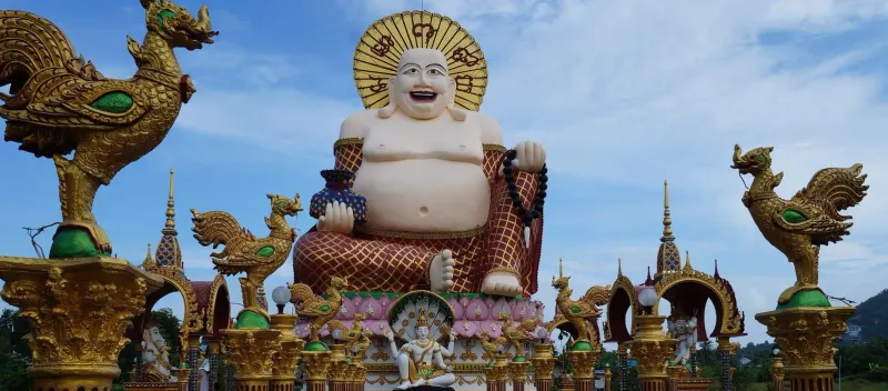 20-meter laughing Buddha statue flanked by golden dragons at Wat Plai Laem Koh Samui