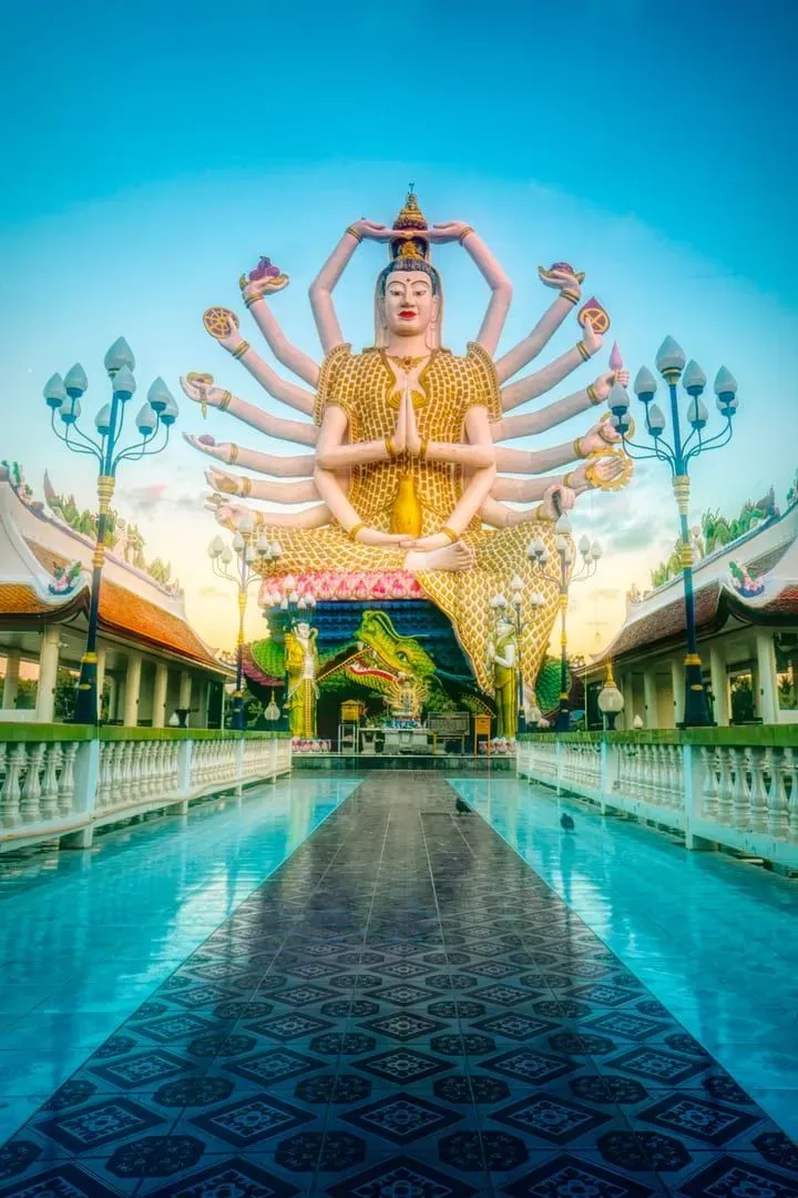 Close-up of the multi-armed Guanyin statue at dusk at Wat Plai Laem temple Koh Samui