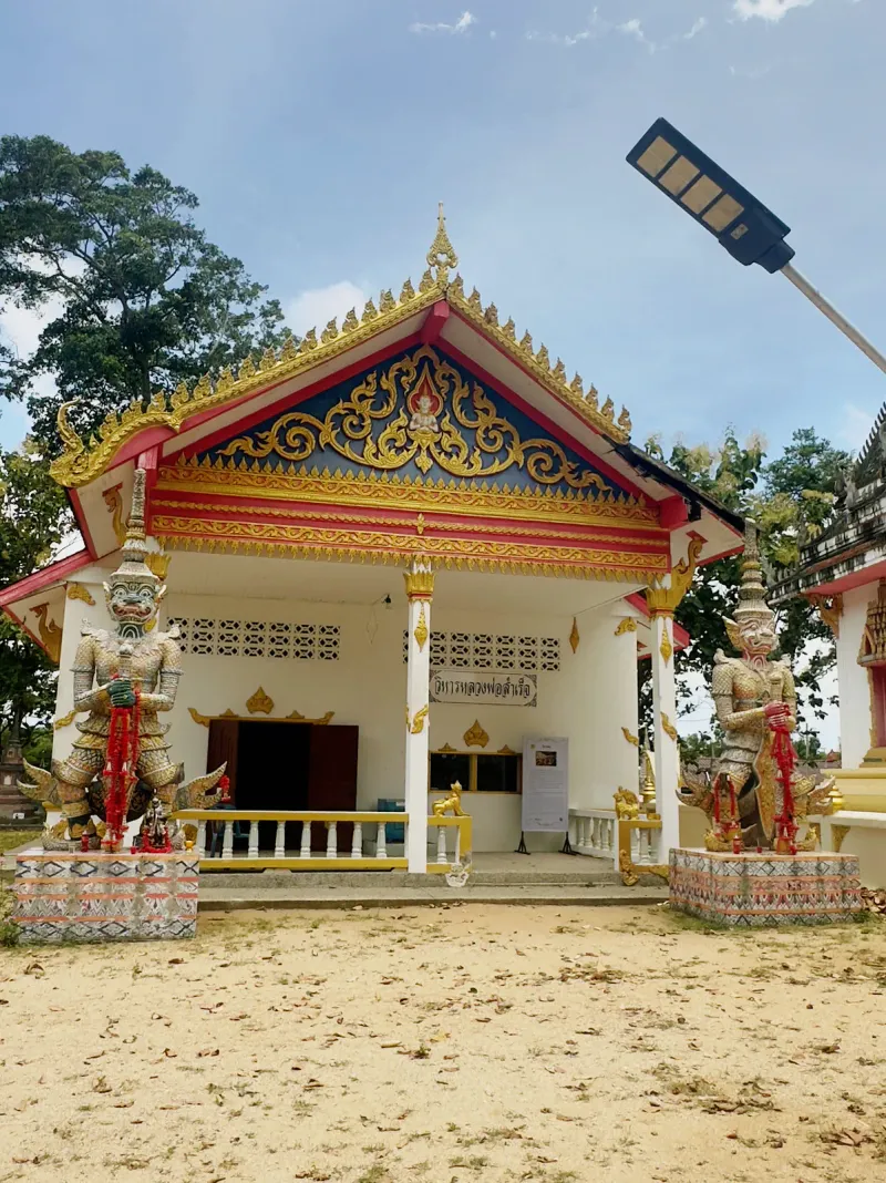 Two colorful yaksha guardian statues flanking the entrance of a Wat Samret pavilion