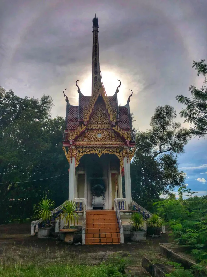A temple pavilion silhouetted against a glowing sky at dusk