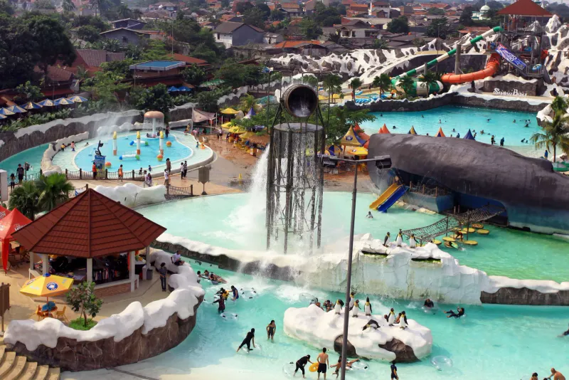An aerial view of a lively water park with pools and slides