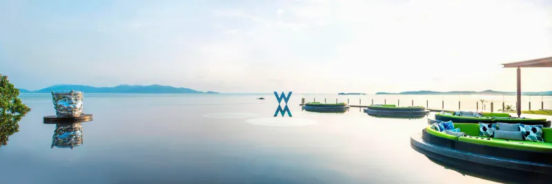 La piscine à débordement du WOOBAR au W Koh Samui, avec ses plateformes circulaires de transats et une vue paisible sur le golfe de Thaïlande