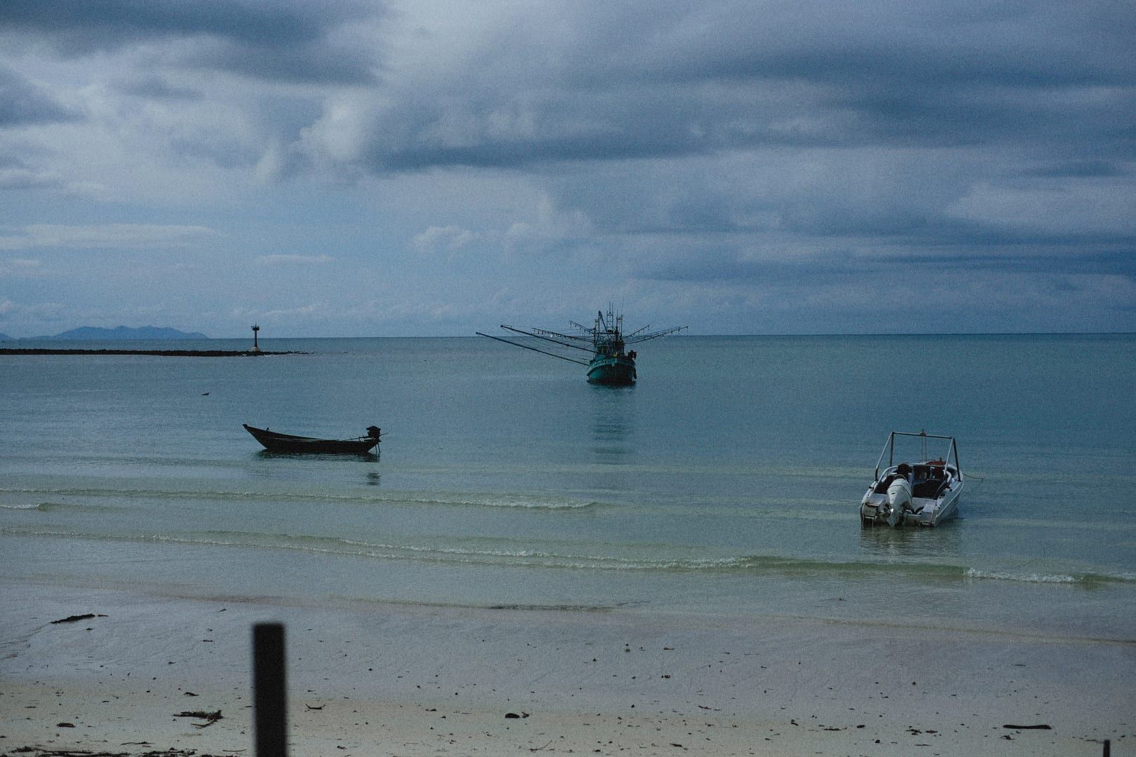 Vor Bang Makham Beach auf Koh Samui verankerte Longtail-Fischerboote unter bewölktem Himmel