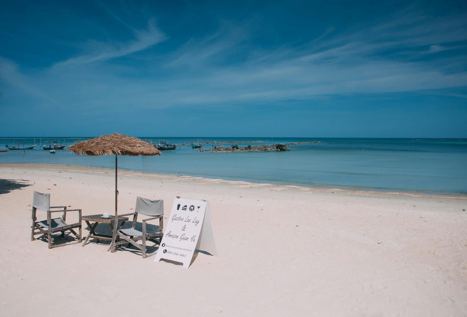 Beach chairs and parasol on Chaweng Noi Beach Koh Samui under a bright sunny sky