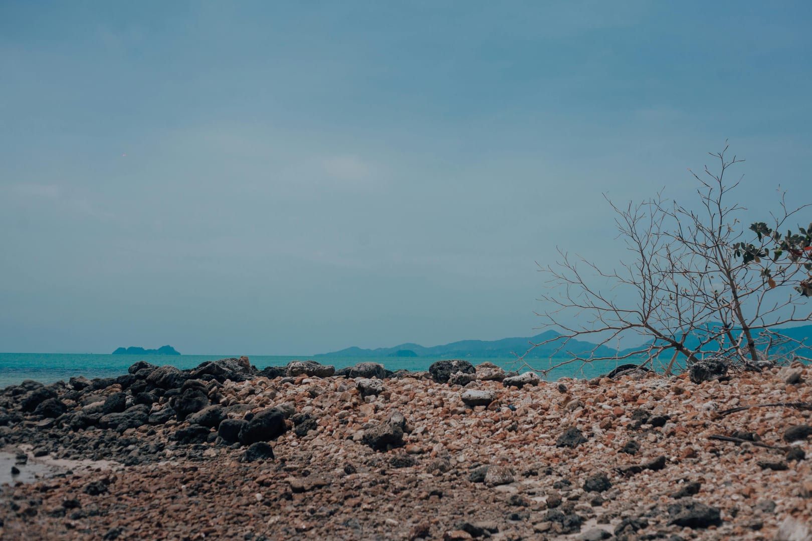 Rocky coastline with turquoise sea and island views near Choeng Mon Beach