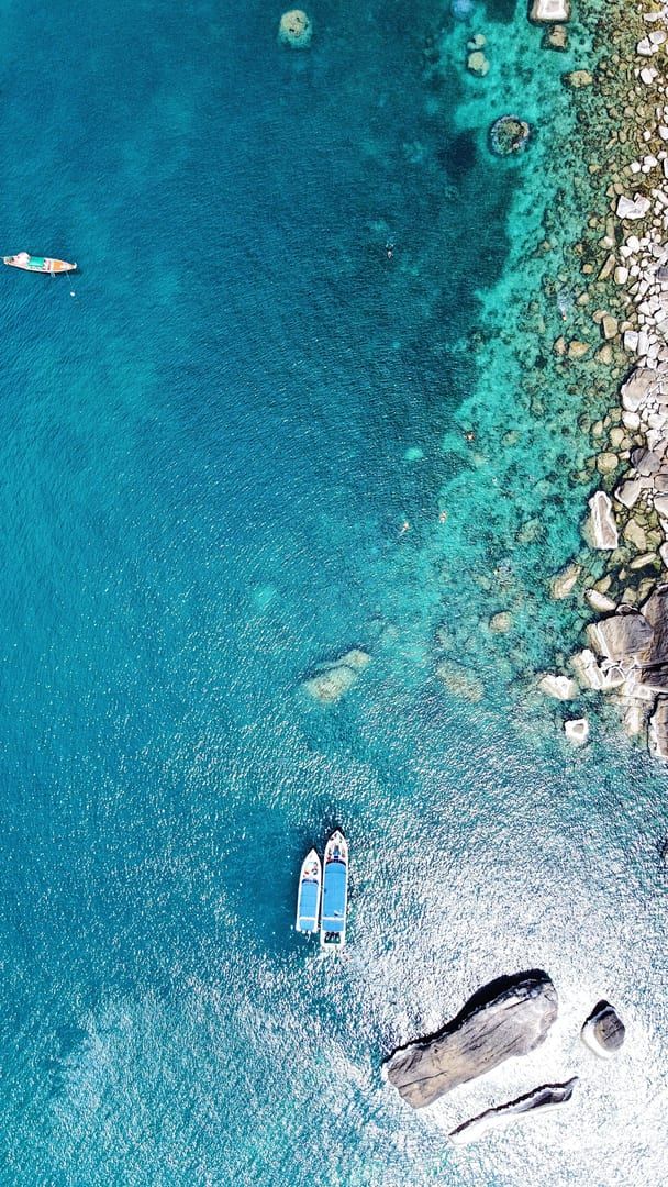 Aerial view of turquoise water and rocky shore ideal for snorkeling at Coral Cove Koh Samui