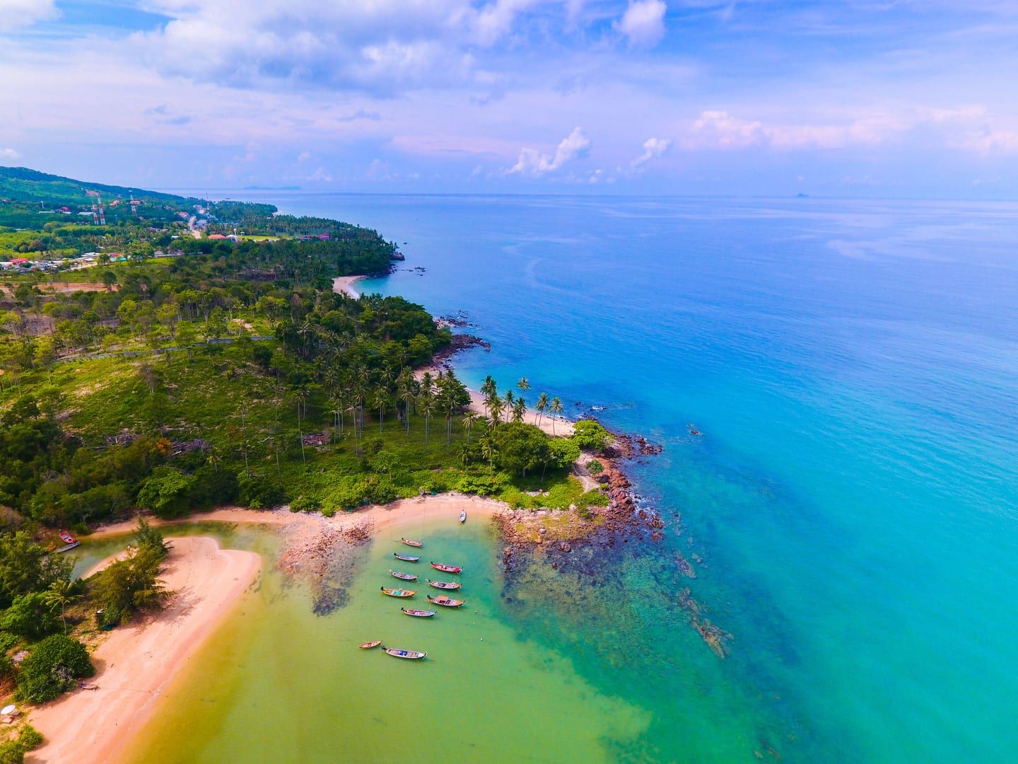 Aerial view of a tropical shoreline with clear water near Koh Taen off Koh Samui