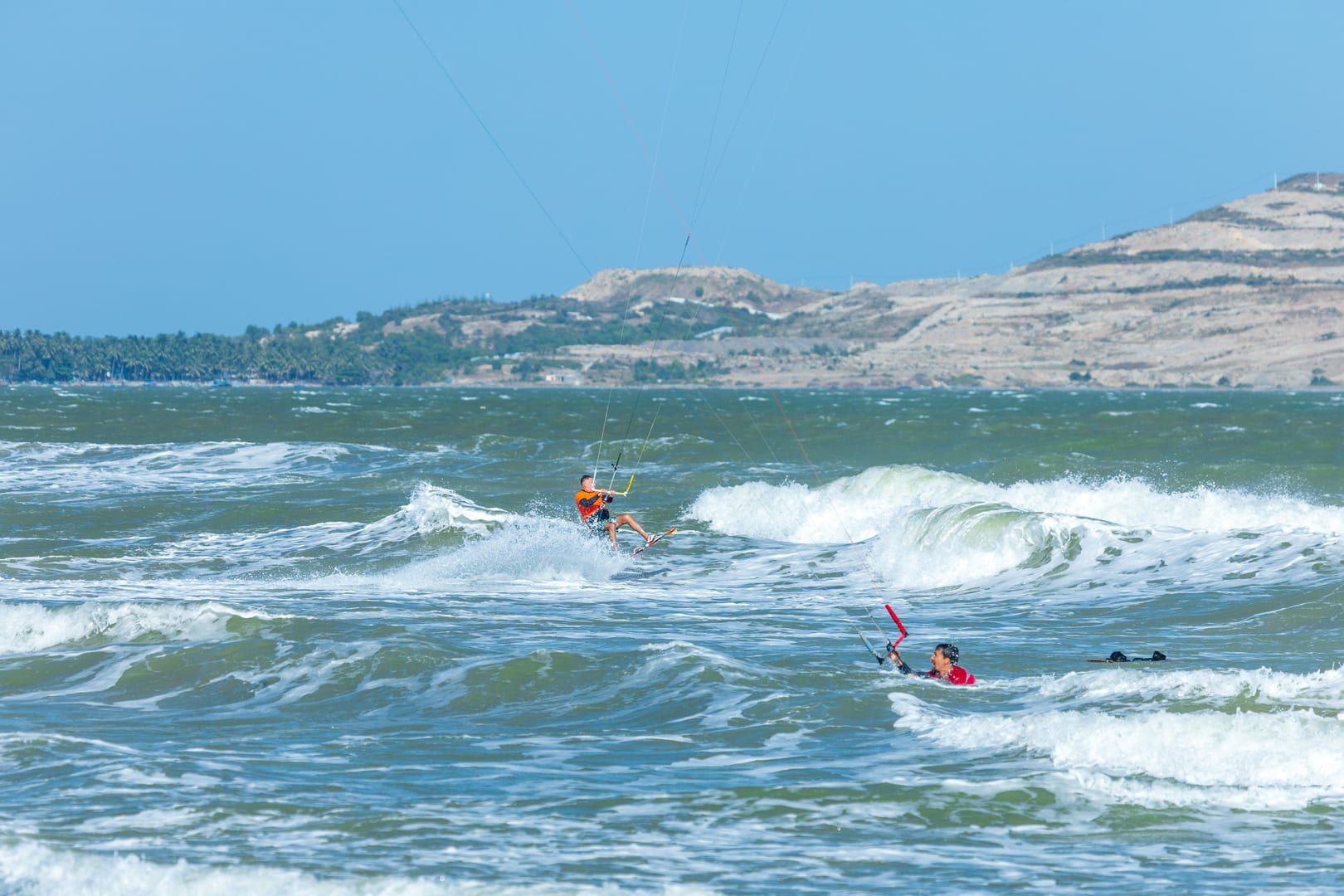 Group of kitesurfers riding the wind together at Na Khai Beach on Koh Samui's quiet south coast