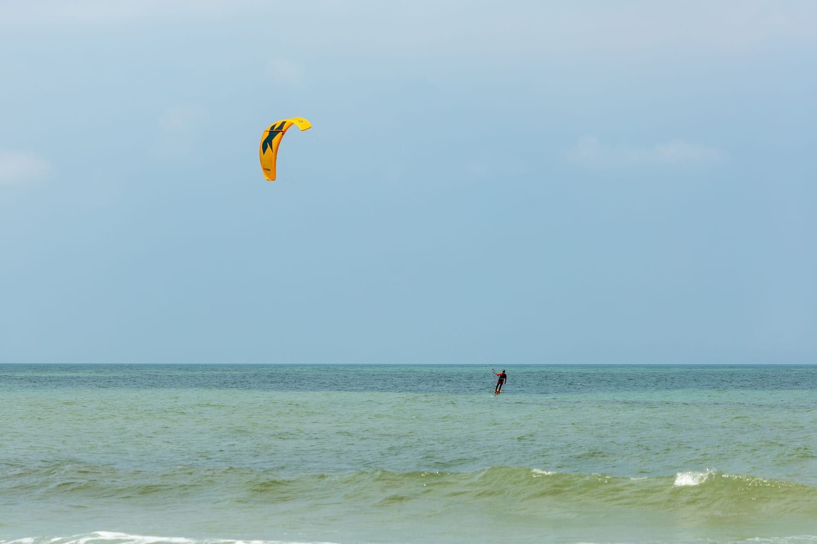 Kitesurfer gliding across the shallow lagoon at Na Khai Beach on Koh Samui's south coast