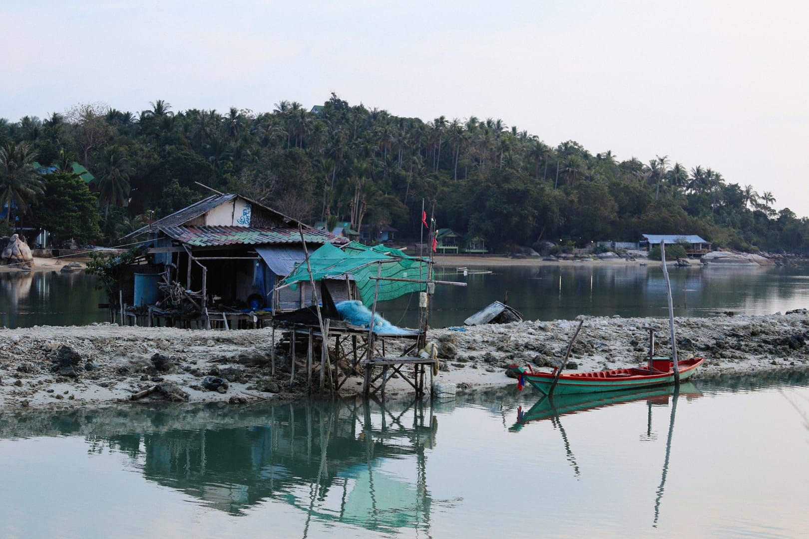 Traditional wooden fishing shack beside calm water near Thong Krut pier on Koh Samui
