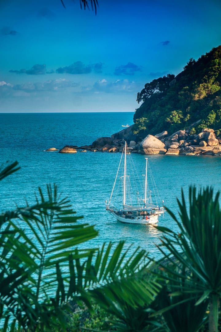 Sailboat off the lush coastline near Thongson Bay Koh Samui