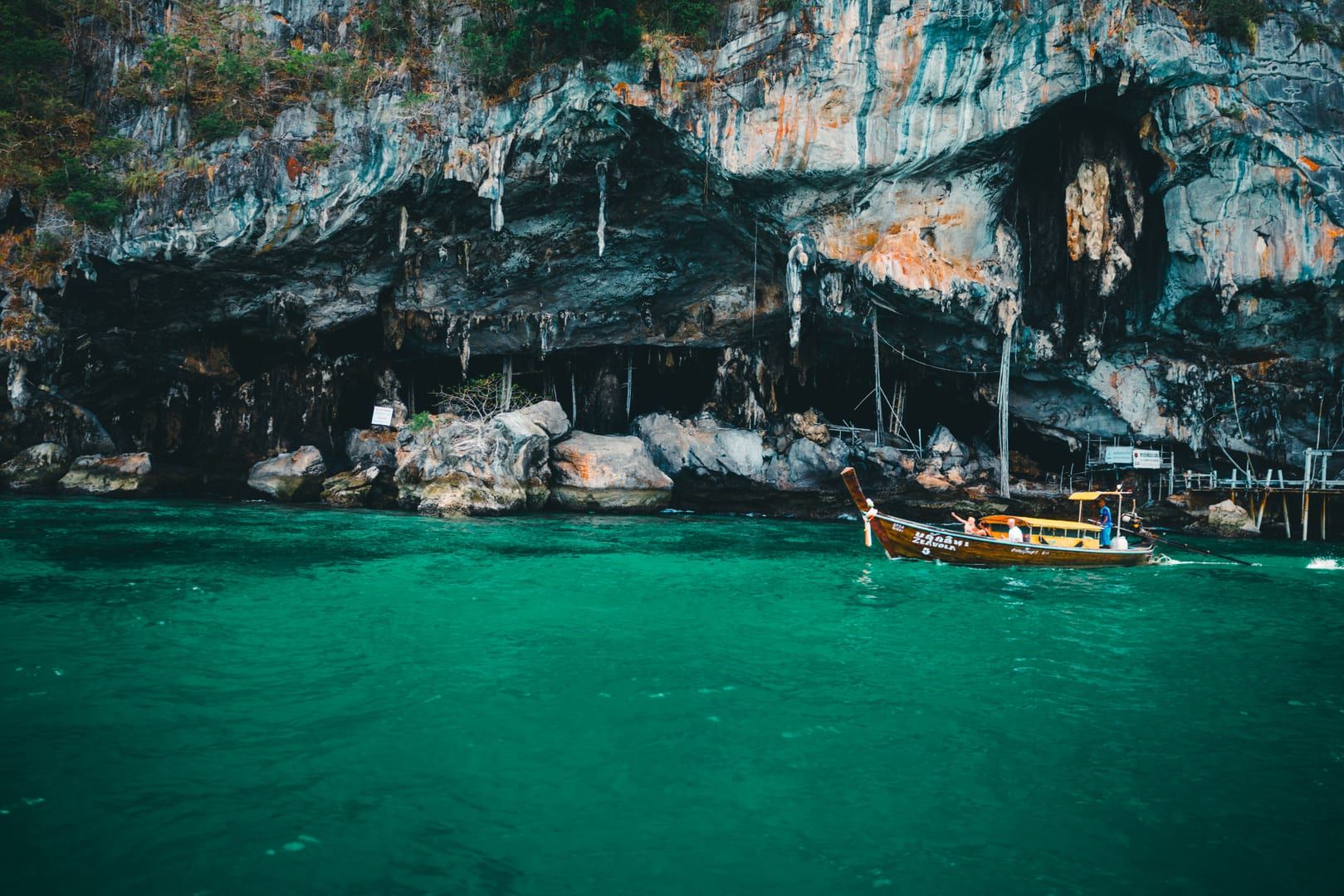 Longtail boat cruising past limestone cliffs on an Ang Thong National Marine Park day trip from Koh Samui