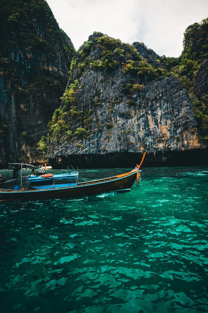 Longtail boat sailing through emerald waters of Ang Thong National Marine Park