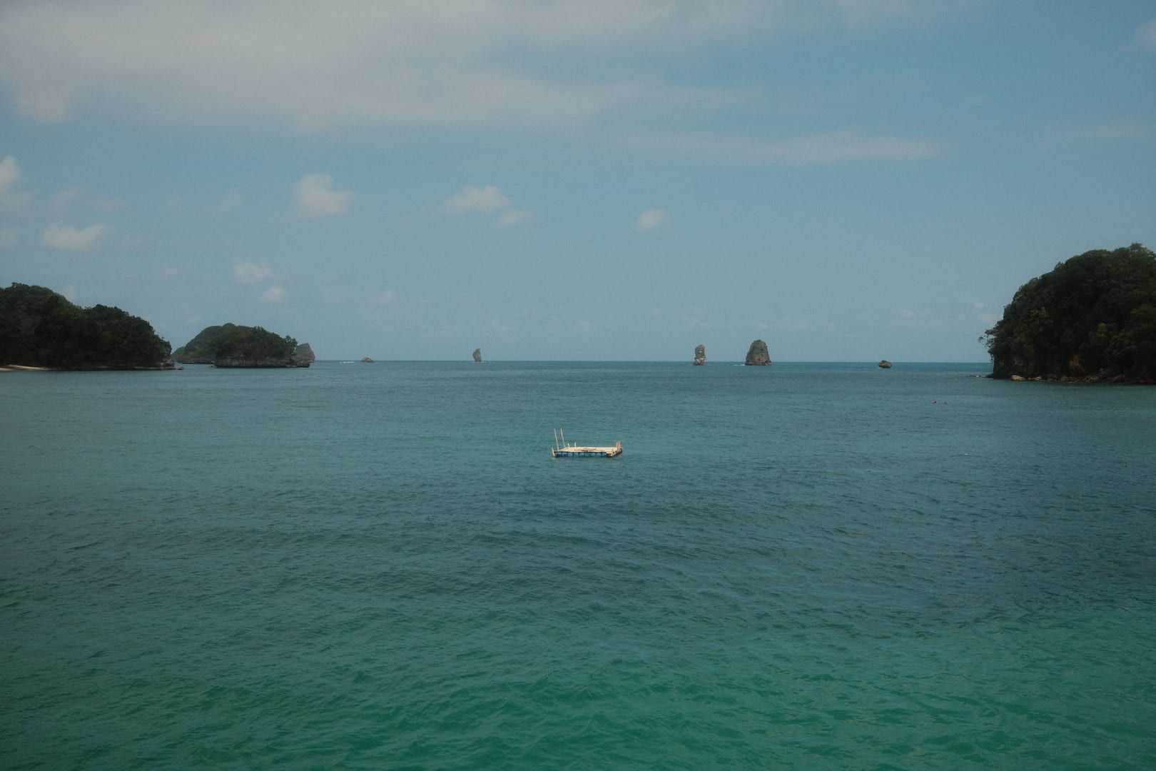 Limestone karst islets and a floating pontoon in the turquoise bay at Ang Thong National Marine Park near Koh Samui