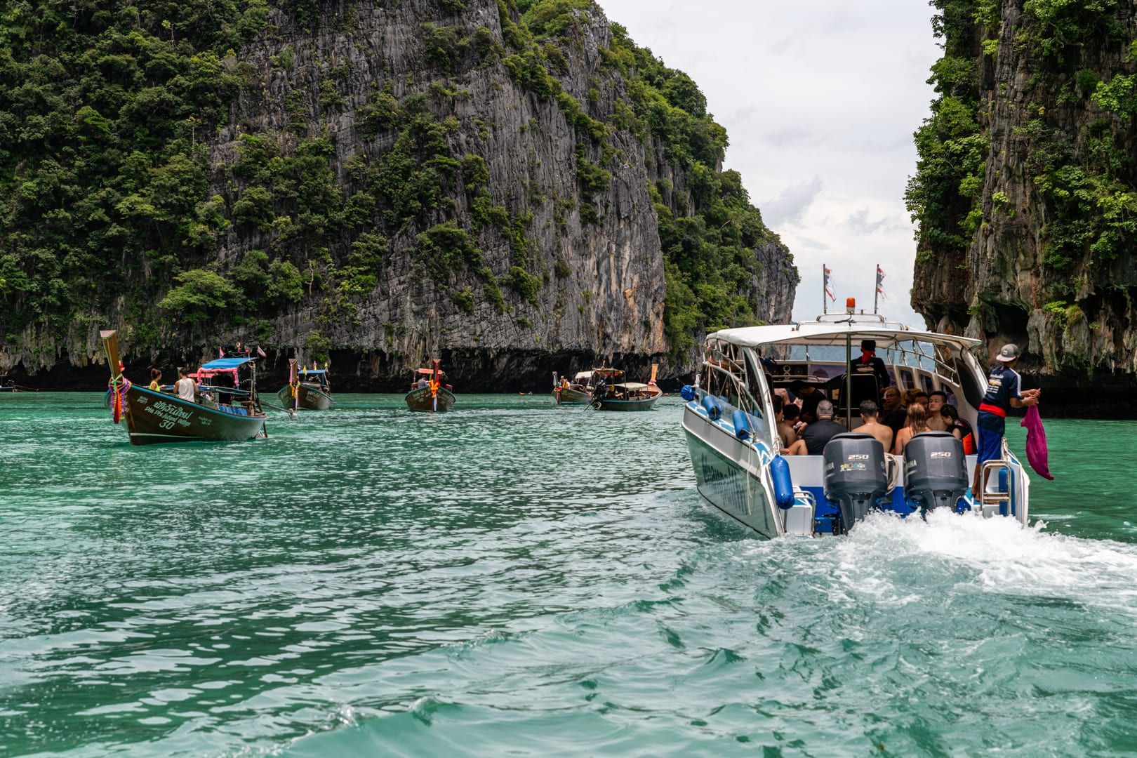 Tourist speedboat weaving between towering limestone islands on an Ang Thong boat tour from Koh Samui