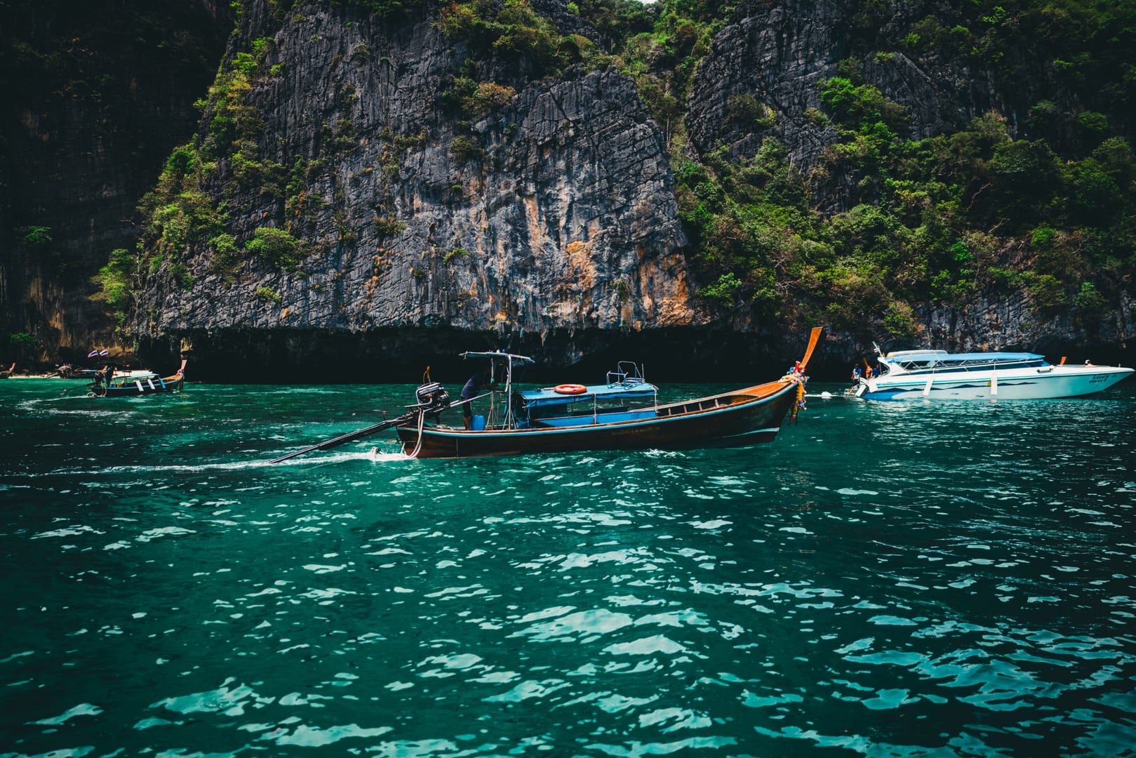 Longtail boats gathered beneath karst cliffs on an Ang Thong day trip from Koh Samui