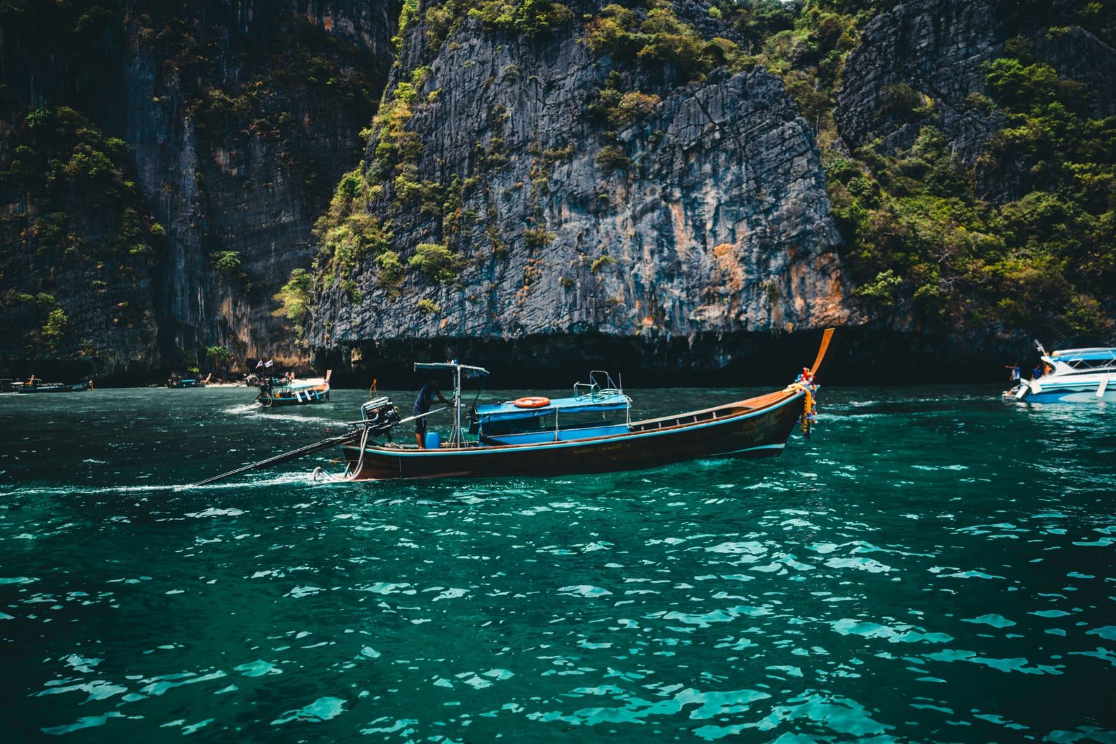 Speedboat and longtail boat anchored near limestone islands during an Ang Thong boat tour
