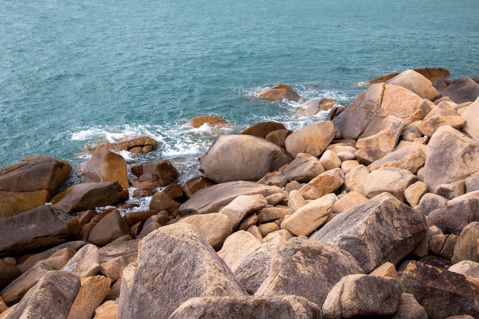 Nahaufnahme großer abgerundeter Granitfelsen entlang der Küstenwanderung Coral Cove Silver Beach