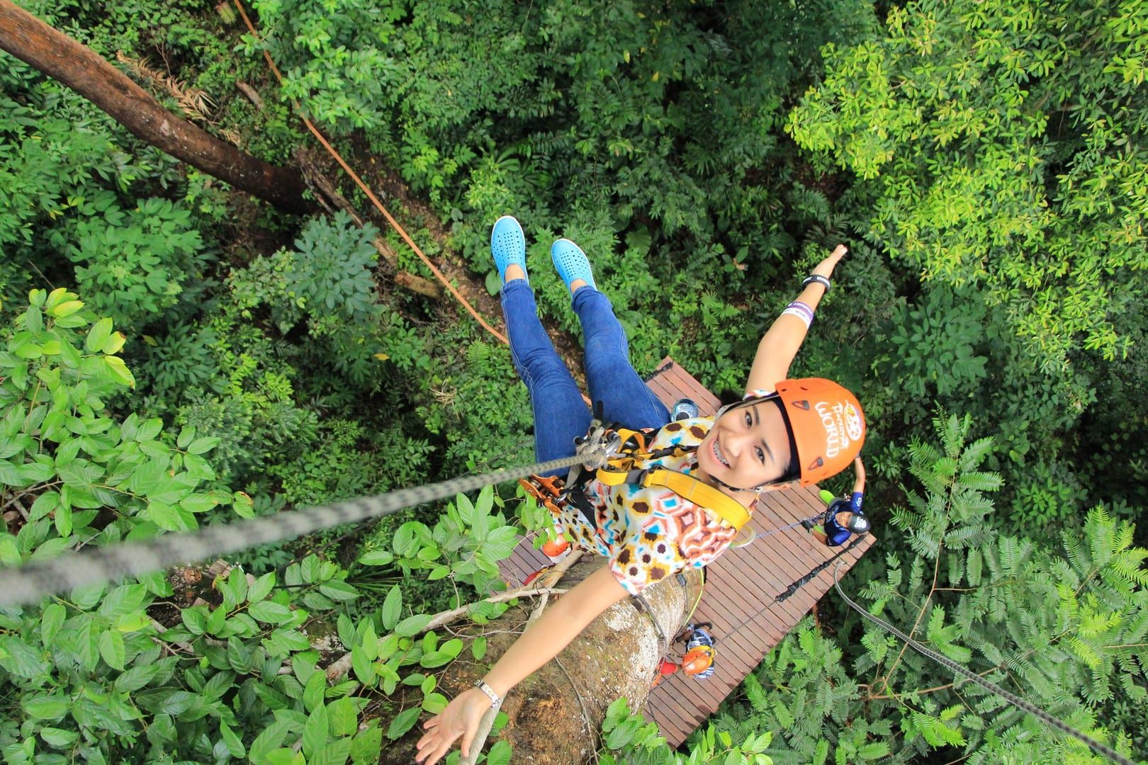 Zipline rider in a helmet enjoying a forest canopy ride like the Lamai Viewpoint zipline