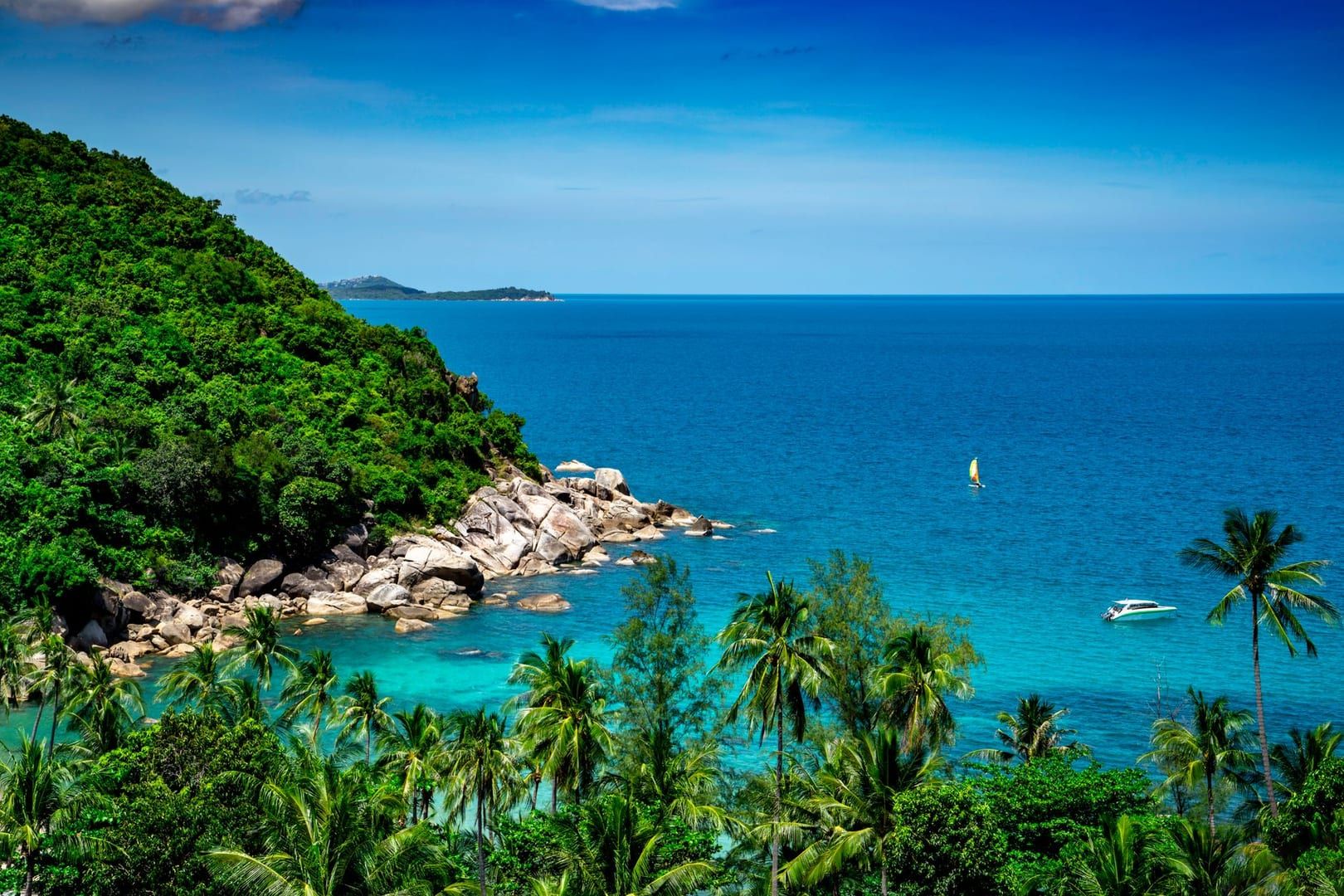 Tropical coastline with lush greenery and azure sea viewed from the Koh Samui ridge trail