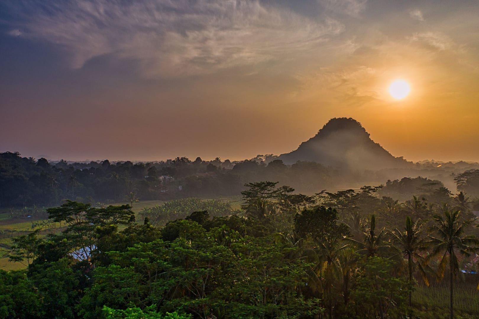 Sunset silhouette over jungle-covered hills on the Nathon ridge hike Koh Samui