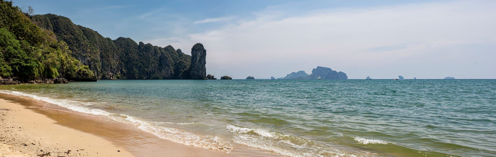 Serene beach cove framed by lush jungle cliffs near Koh Samui southeast coast