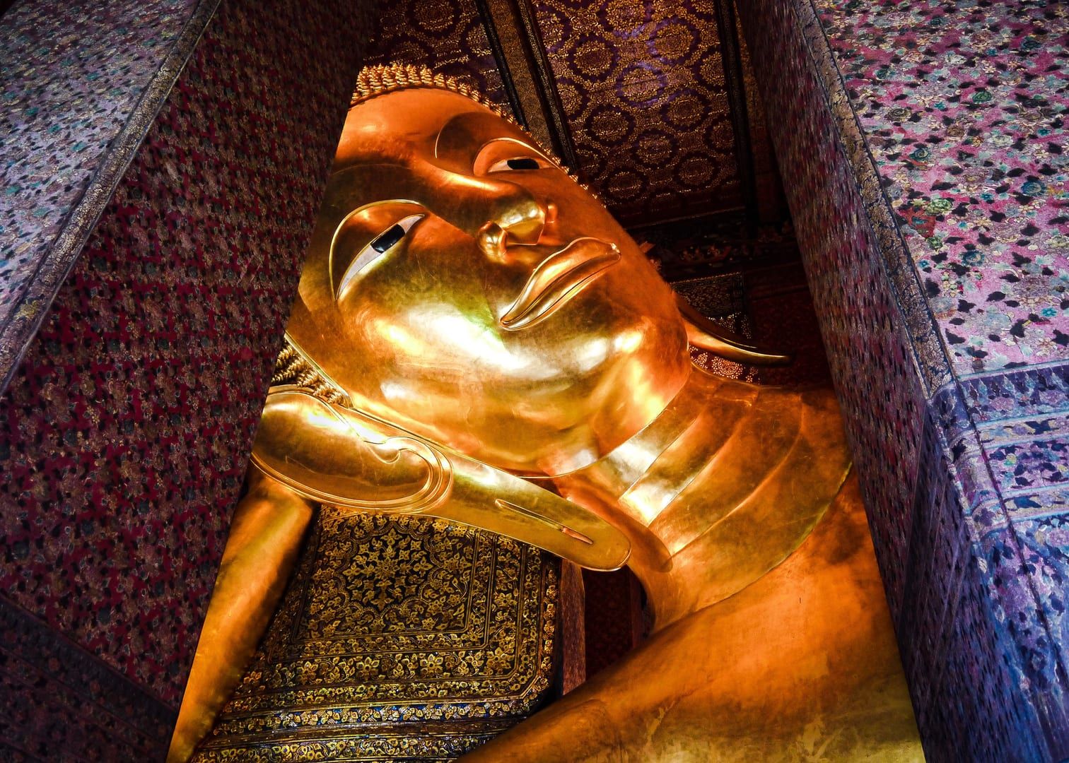 Close-up of a golden reclining Buddha statue representing the trail's jungle shrine